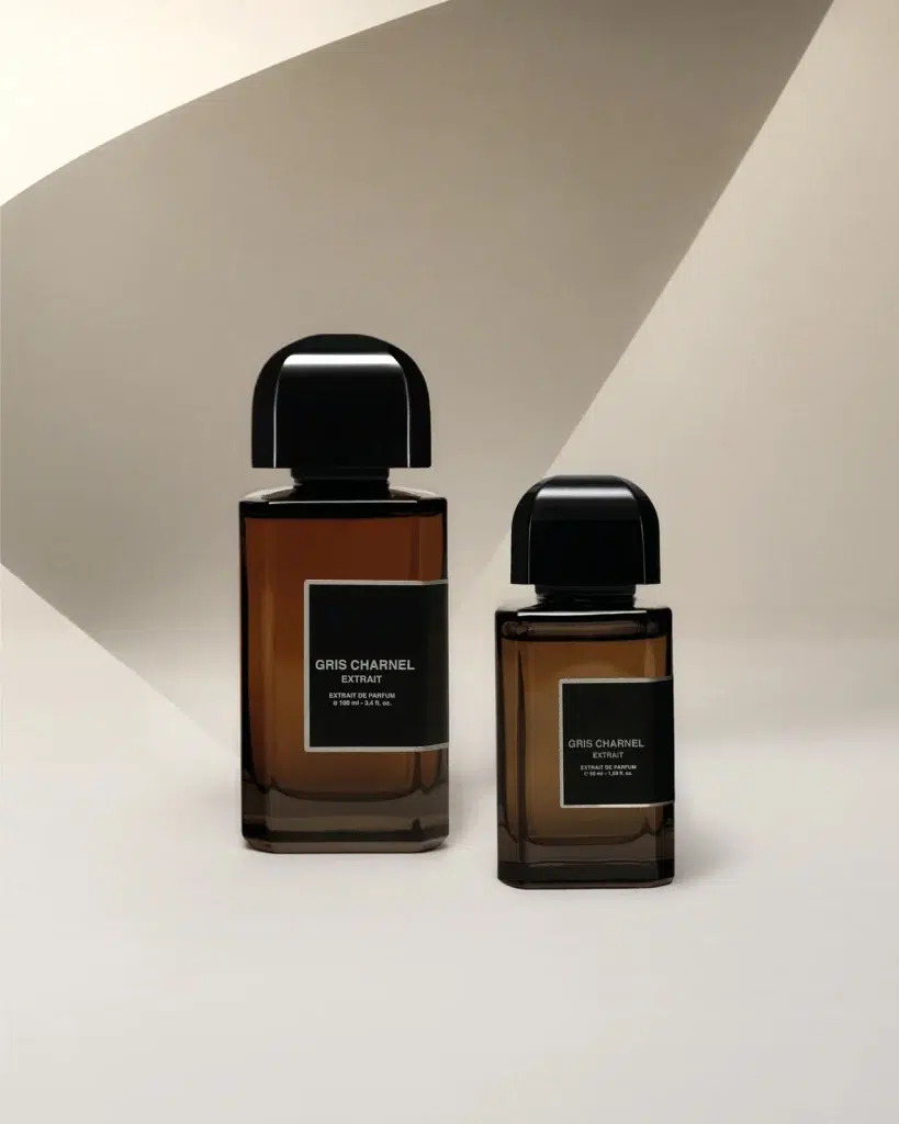 Два флакони BDK Parfums Gris Charnel Extrait на світлій поверхні в геометричному малюнку сонячних тіней