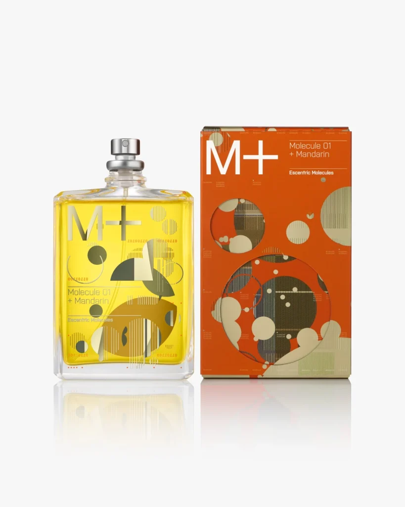 Флакон Escentric Molecules Molecule 01 + Mandarin із жовтою рідиною поруч із помаранчевою коробкою на світлому тлі